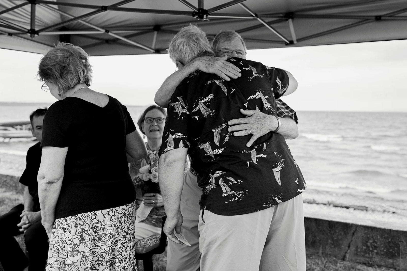 Seniors embracing at a beach gathering