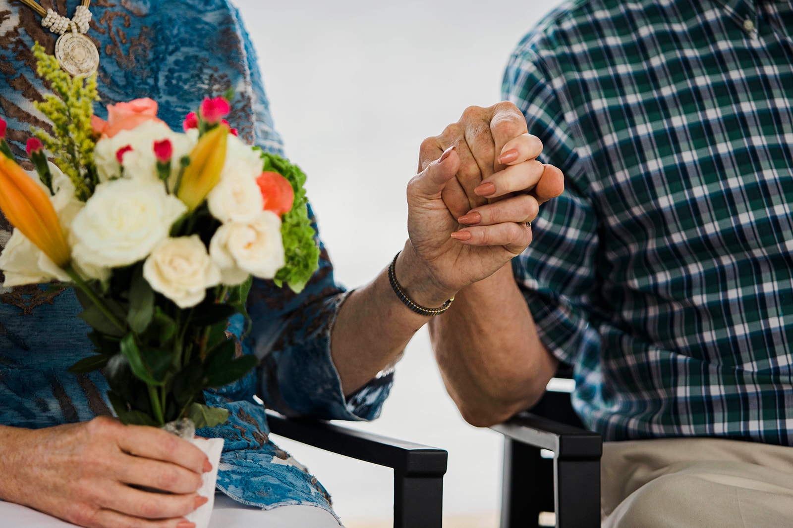 Couple holding hands with a flowers bouquet